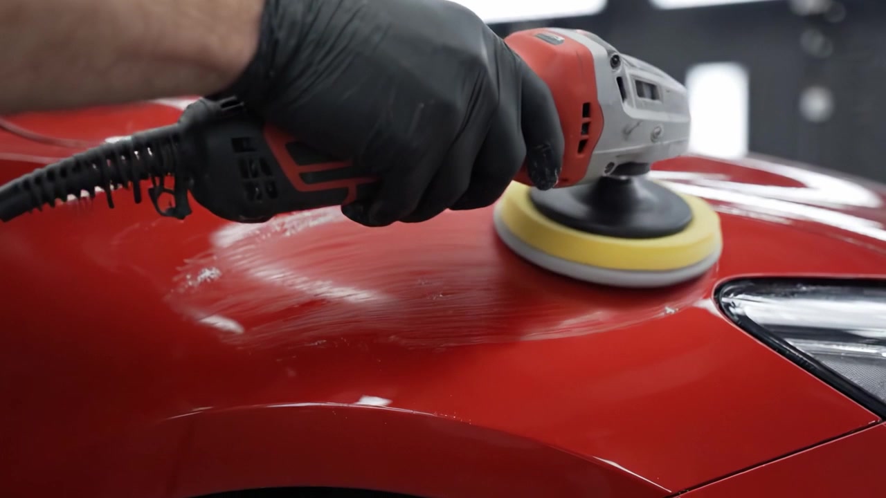 Um Procedimento Profissional de Detalhamento Automotivo: Polindo a Superfície de um Carro Vermelho com Precisão e Cuidado para um Acabamento Impecável Usando uma Politriz