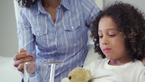 front view of african american mother feeding her son food in bed in the ward at hospital 4k