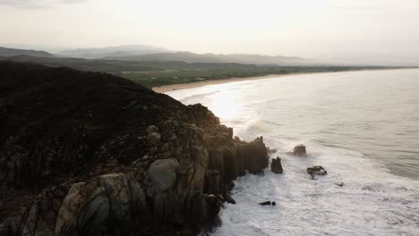 Rocky-sea-cliff-battered-by-ocean-waves-with-eroded-coastal-cliffs-reveals-Puerto-Escondido-Oaxaca-Mexico