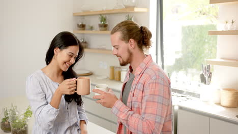 Una-Pareja-Diversa-Disfruta-De-Una-Bebida-Caliente-En-La-Cocina-De-Casa