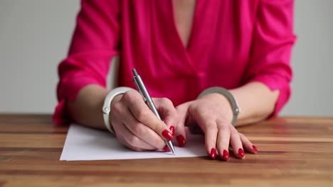 person in handcuffs writing on paper