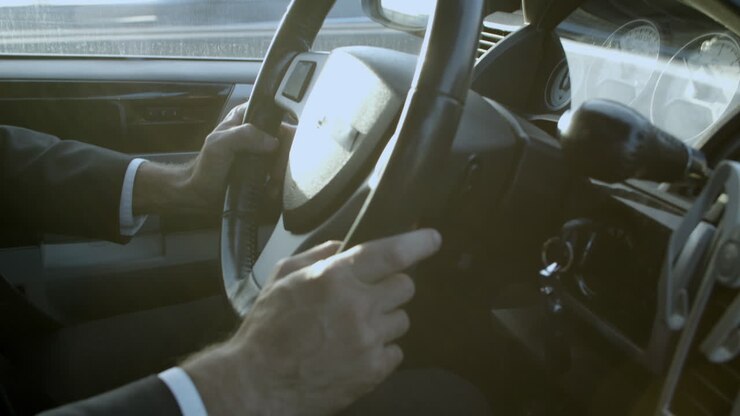 Primo piano delle mani di un conducente sul volante