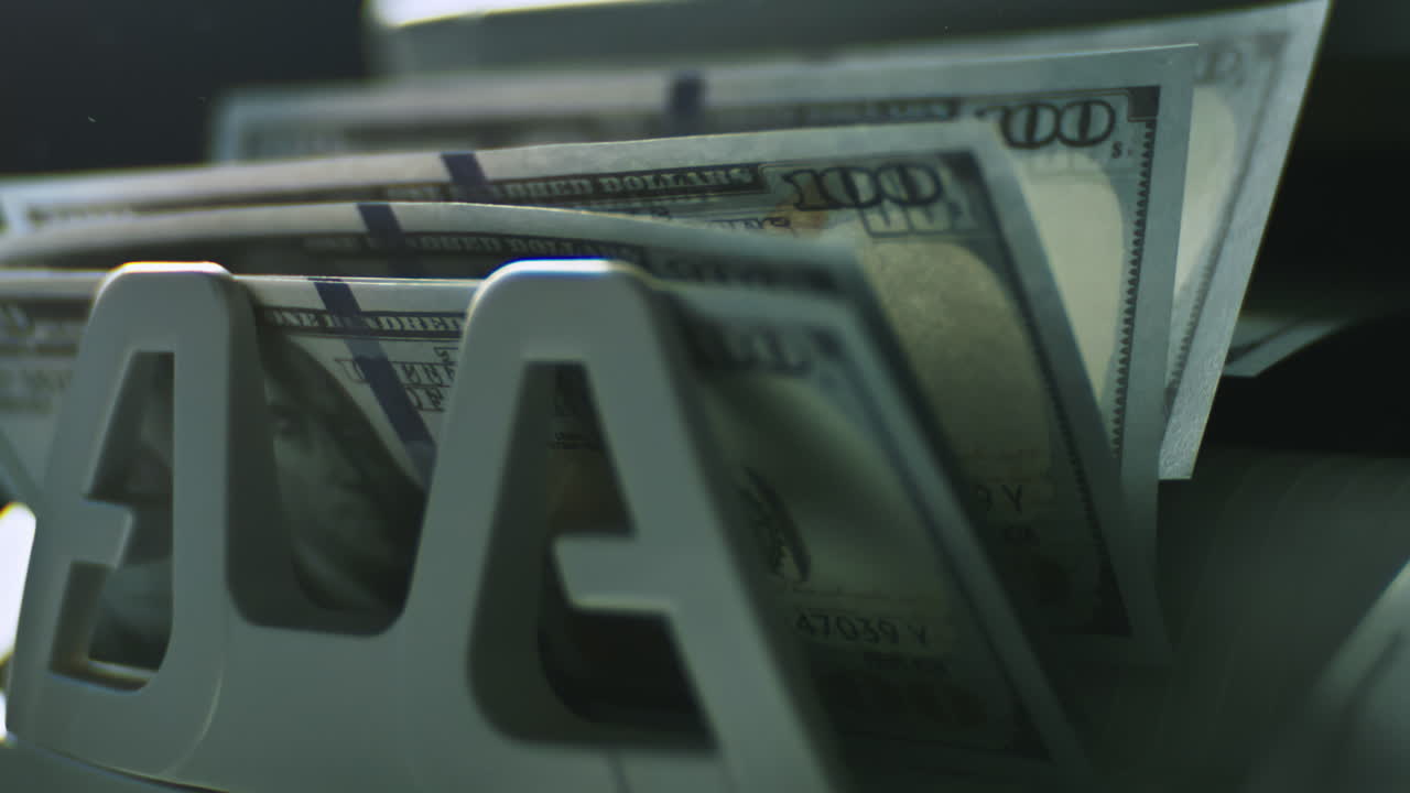 billetes de cien dólares en un dispensador de billetes