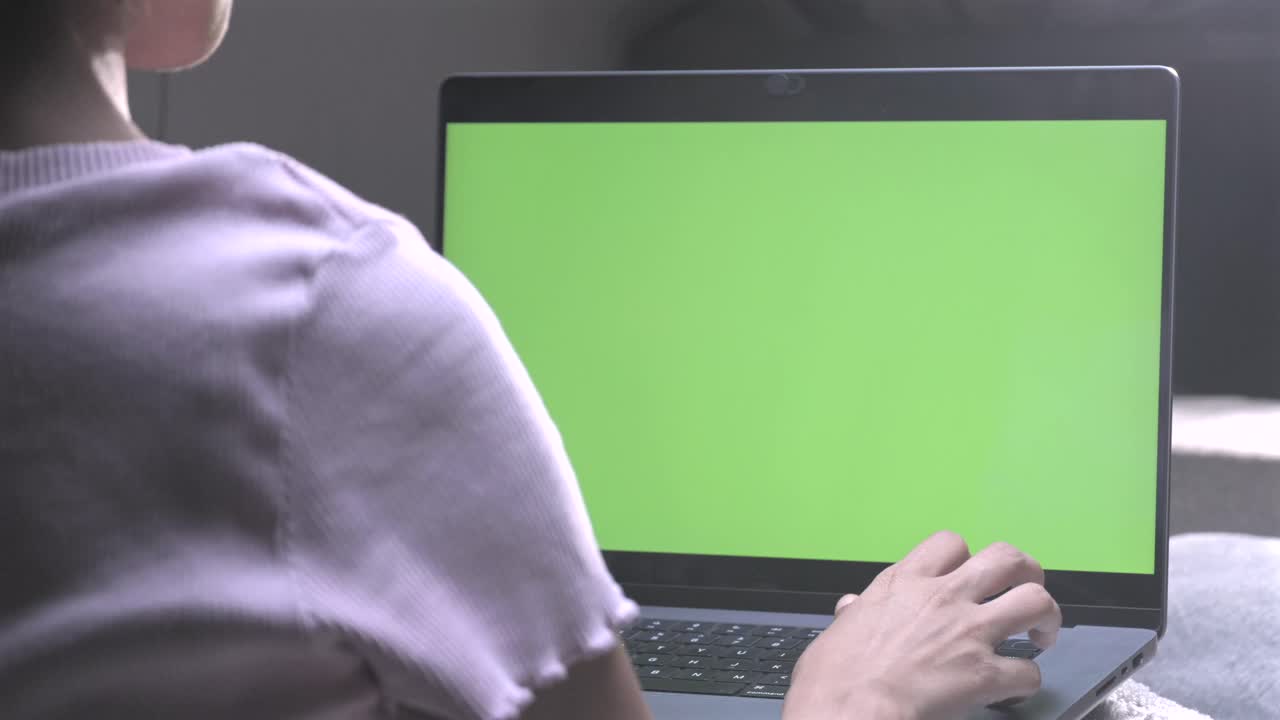 chica usando un portátil con pantalla verde en la pantalla del portátil