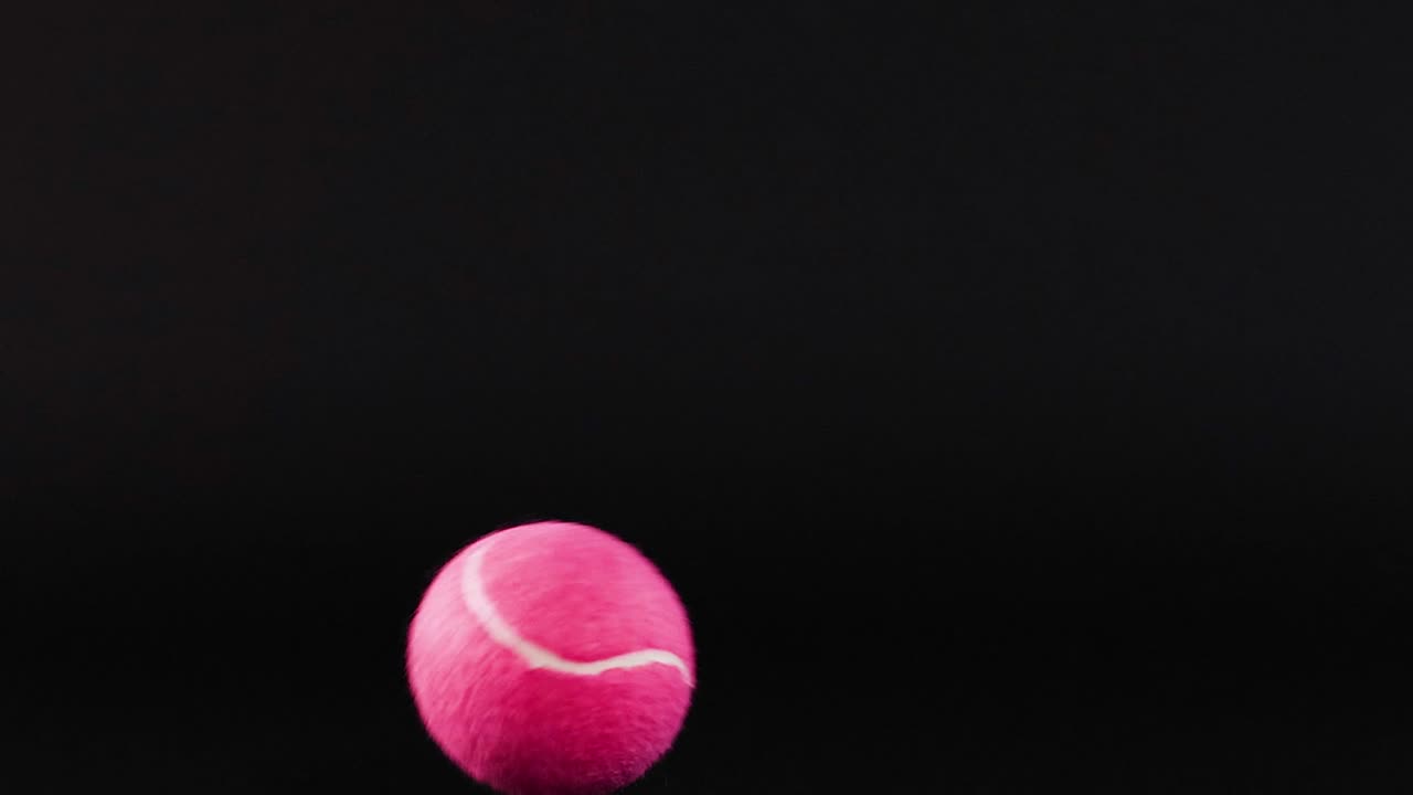 A pink ball moves across a black grid, showcasing dynamic motion and contrast.