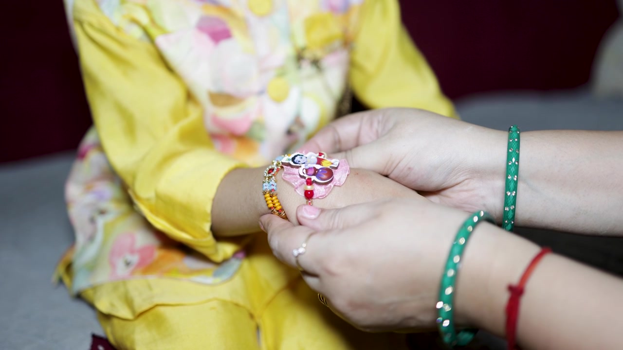 Momento del festival Raksha Bandhan con la sorella che lega il sacro filo rakhi al polso