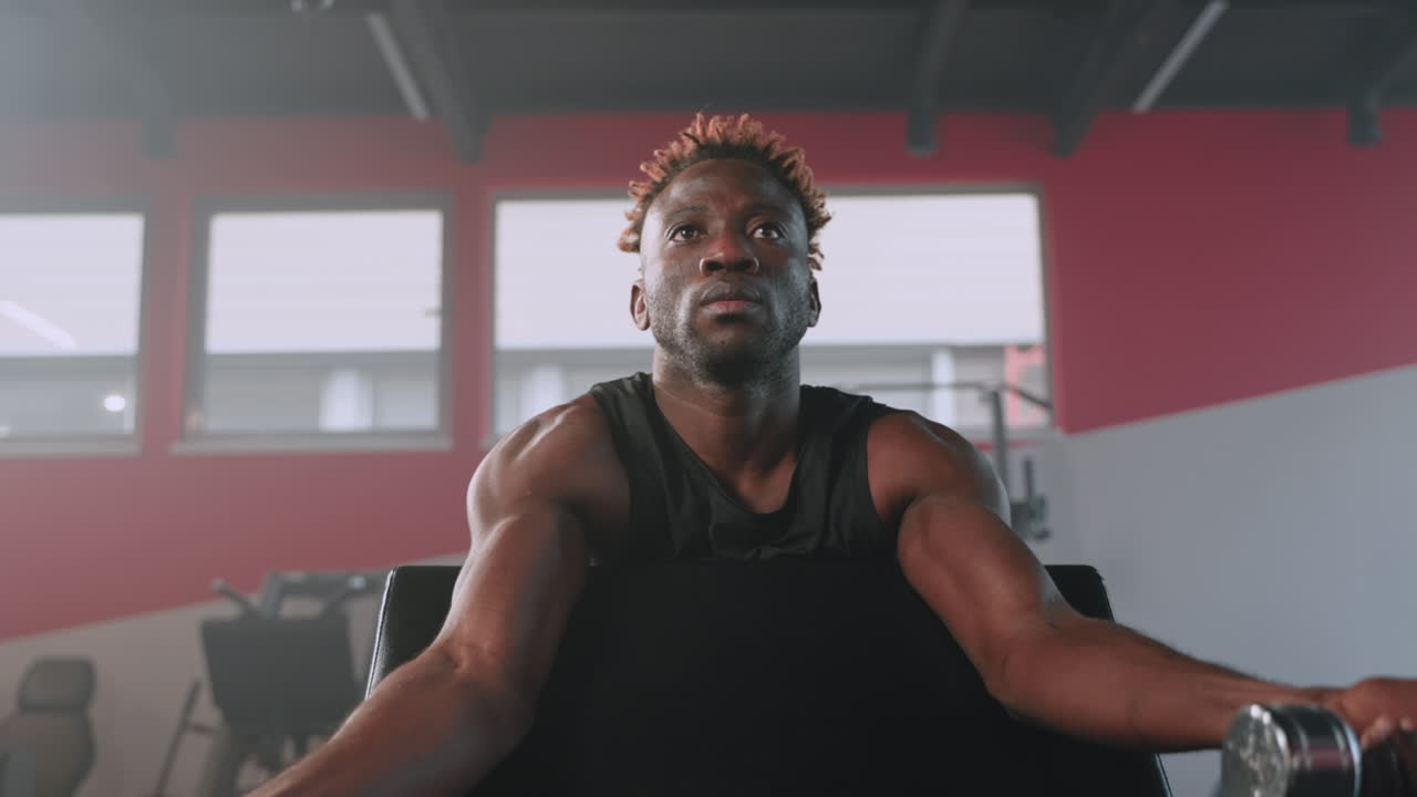Man Exercising with Dumbbells in Gym
