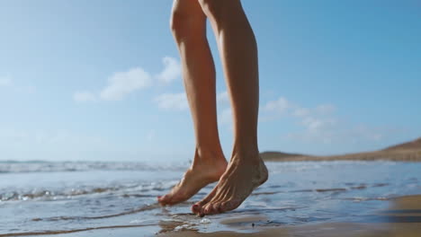 beautiful girl athlete with beautiful breasts in black shorts and a white top crouches and makes a jump up. circular training for the heart. slow motion steadicam