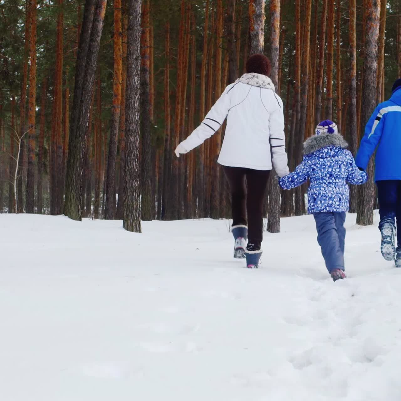 어머니는 눈 속에서 그녀의 두 자녀와 함께 걷는다 01
