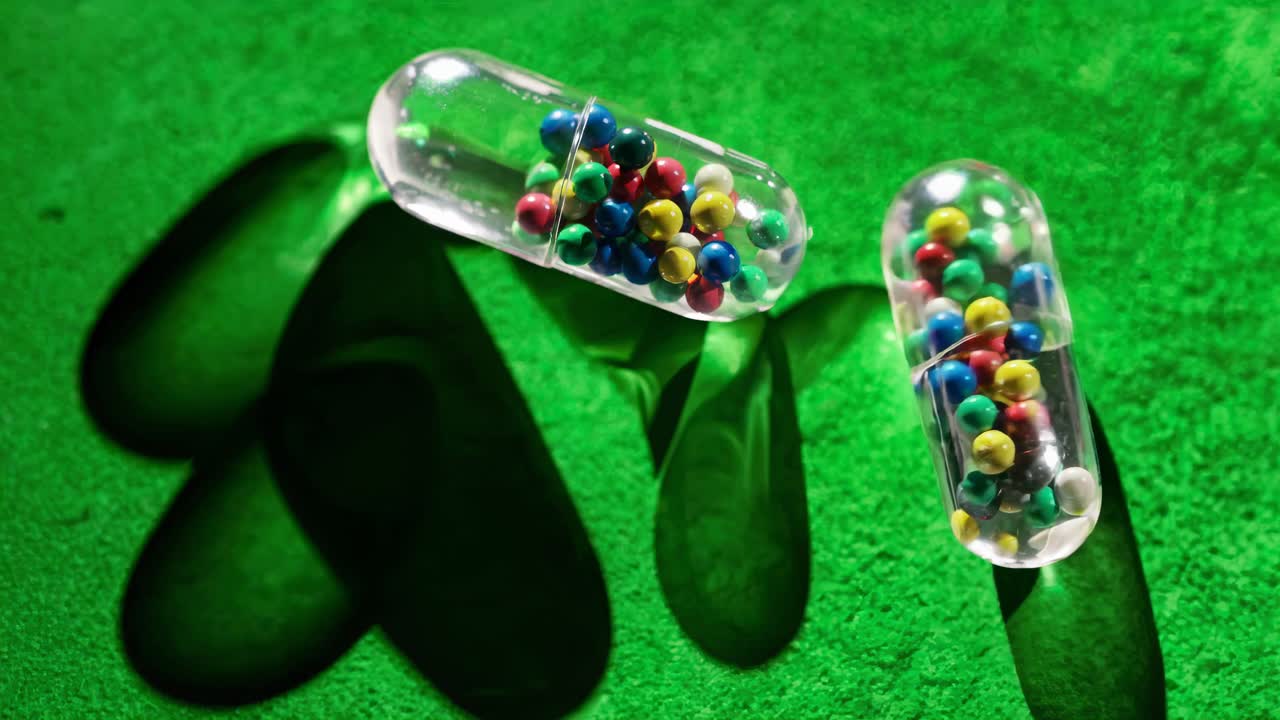 Colorful Medicine Capsules on Green Background