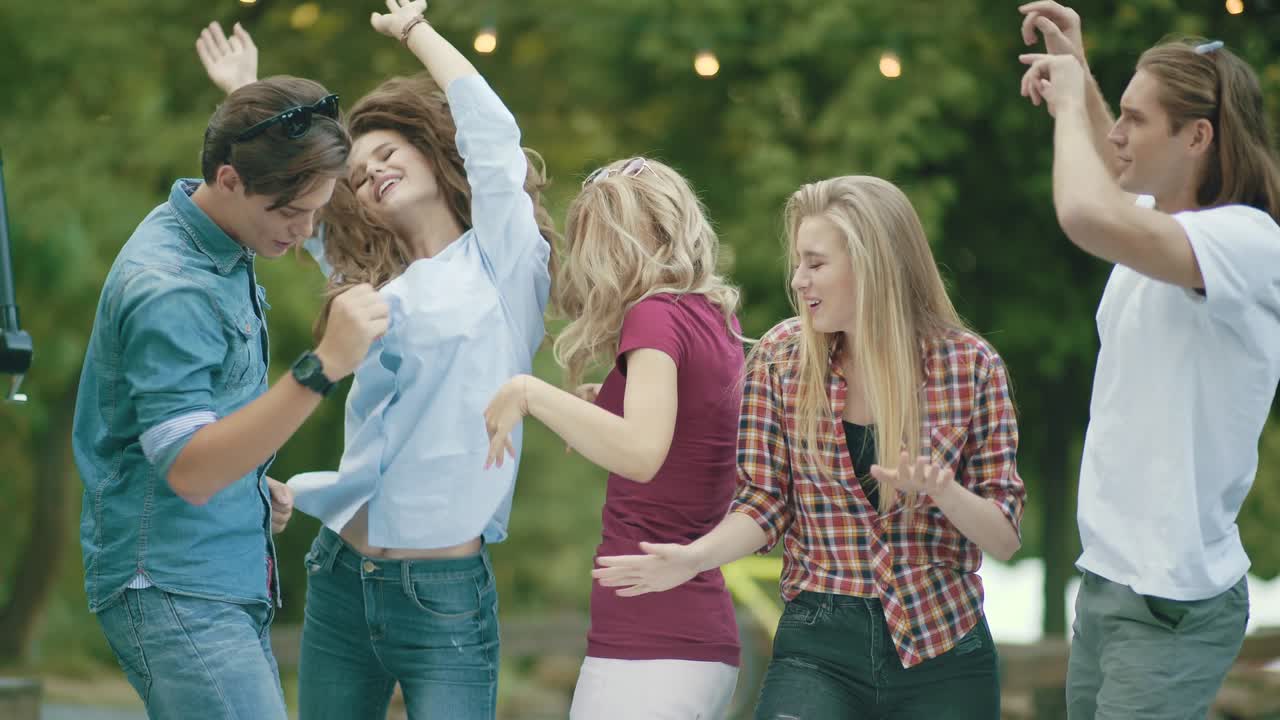 행복한 친구들이 춤을 추고, 재미를 느끼고, 야외 파티를 즐기고 있습니다.