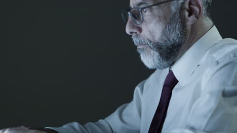 serious businessman using computer in dark office