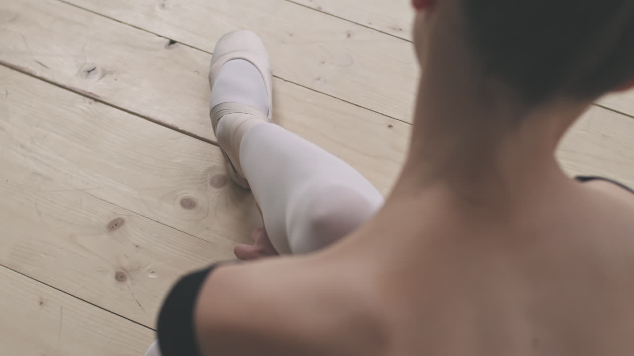Ballerina Tying Ballet Shoes Before Dancing
