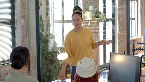 Leading coding meeting, woman discussing software development strategies in modern office