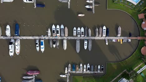 aerial drone view of numerous boats docked at dock of a private golf club