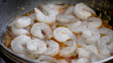 fresh peeled prawns in boiling curry dish over pan