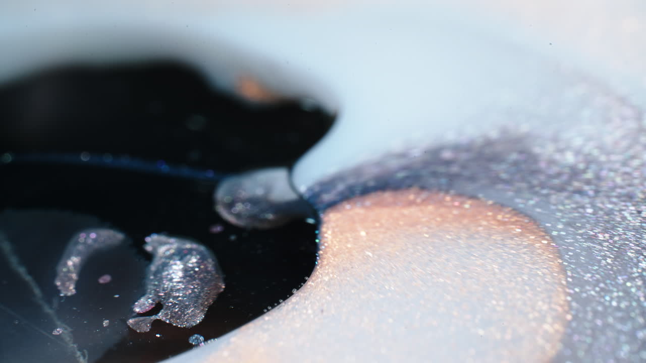 Colorful abstract liquids mix and swirl, creating organic patterns and textures in close-up