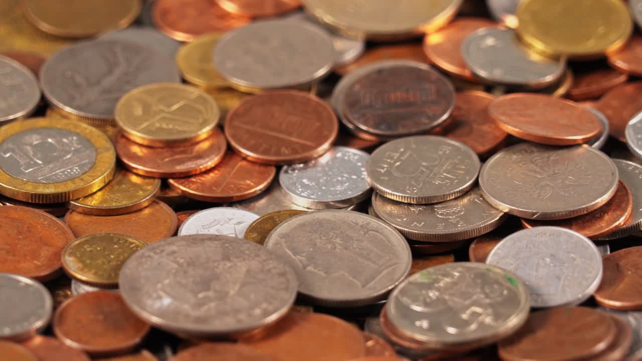 Different types of coins are spread out on a flat surface