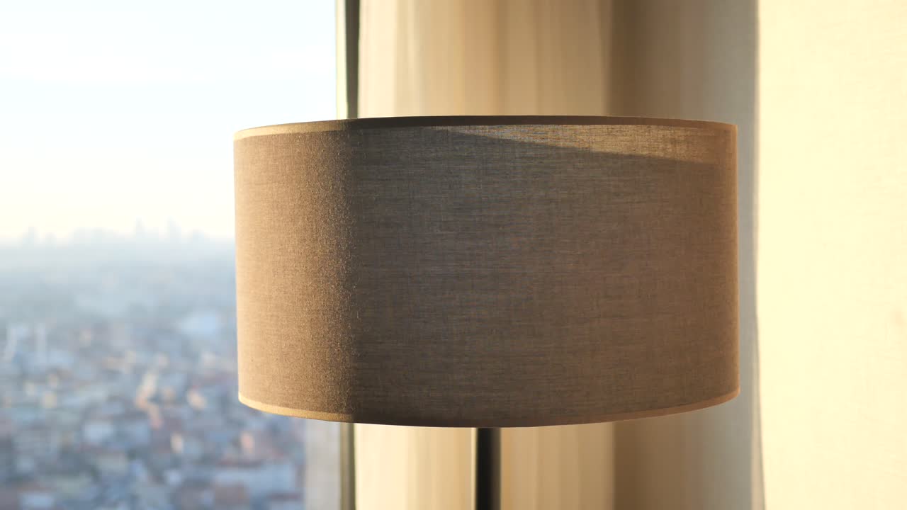 lámpara elegante junto a la ventana con vista a la ciudad