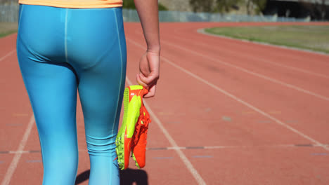 Mid-section-of-female-athlete-walking-with-sport-shoes-on-a-running-track-4k