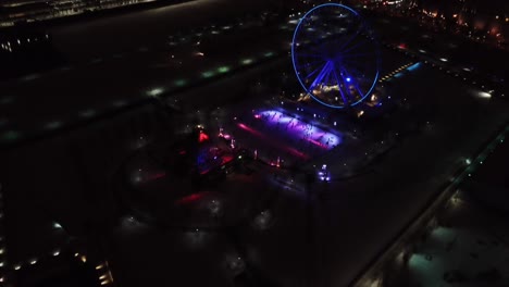 Aerial-clip-of-Montreal,-Canada,-at-night,-with-the-lights-of-a-Ferris-Wheel