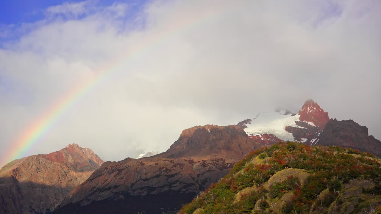 Dramatic Clouds and vibrant Rainbow Above Rugged Patagonian Mountains near El Chalten. Los Glaciares National Park