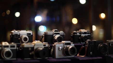 a display of vintage and retro cameras with blurred lights