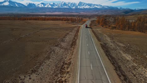 mountain road with truck in autumnal landscape