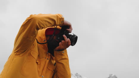 photographer taking photos on winter landscape with dslr camera