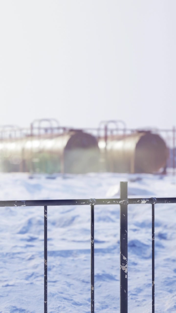 Winterlandschaft mit schneebedecktem Boden und großen Panzern im Hintergrund.