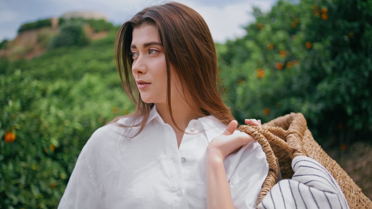 자신감 있는 농부 소녀 가 호두 농장 초상화 를 찍고 있다. 바구니 를 들고 있는 여자