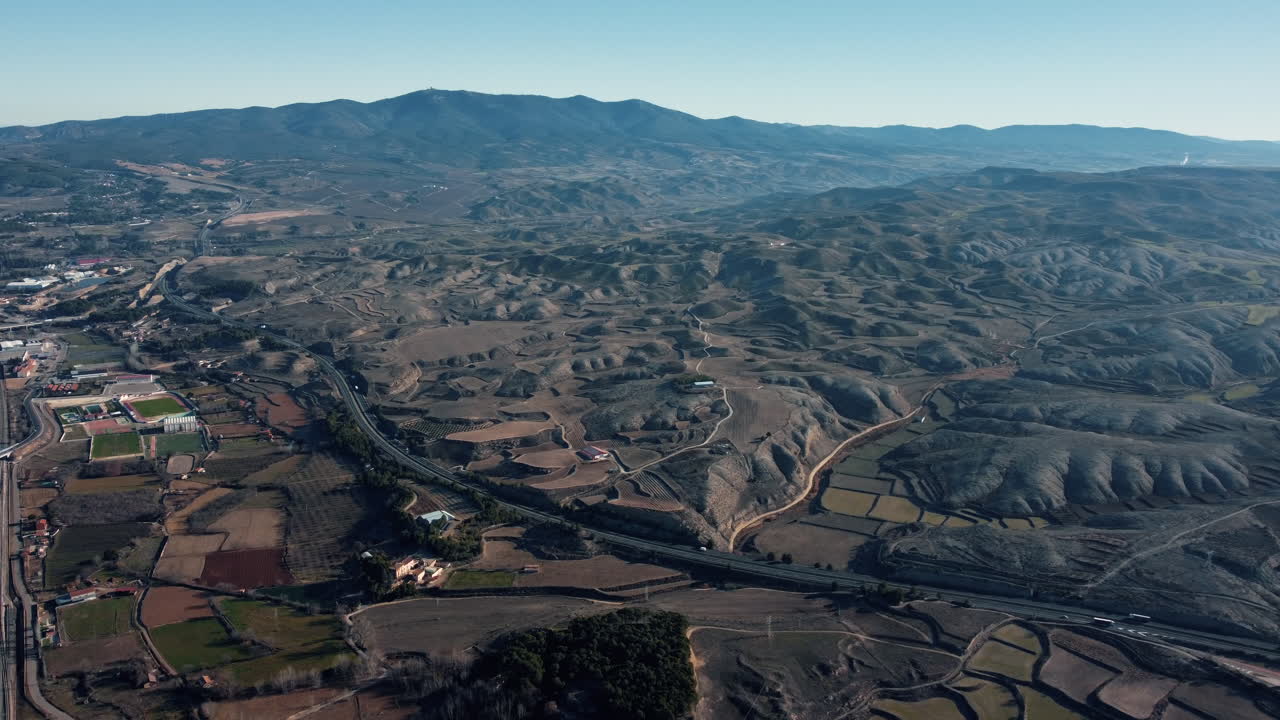vista aérea de un paisaje rural montañoso con carreteras y tierras de cultivo