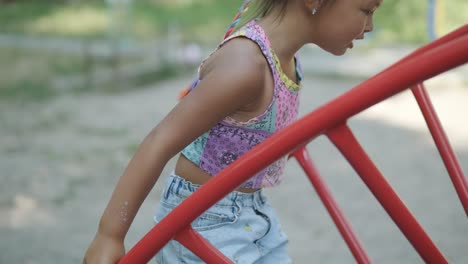 pregnant mother watching daughter play on slide at playground