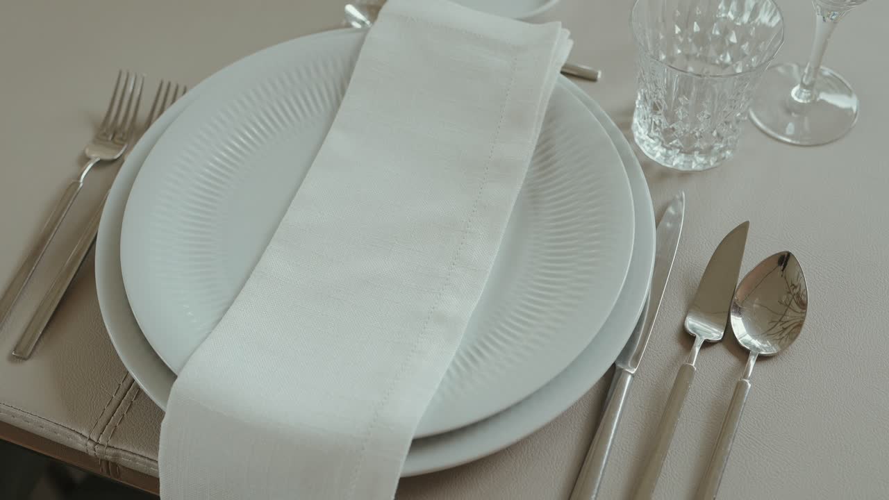 minimal wedding table setup with white plates napkin and silver cutlery