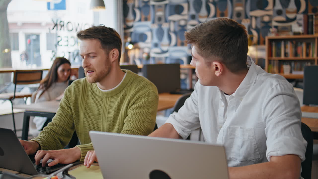 Friendly colleagues working computer together at room. Managers discussing data