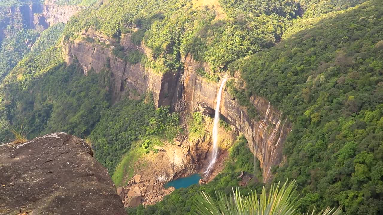 nohkalikai 폭포 cherrapunji meghalaya 인도에서 찍은 상단 각도 비디오에서 녹색 숲에 자리 잡은 산 꼭대기에서 떨어지는 고립 된 폭포