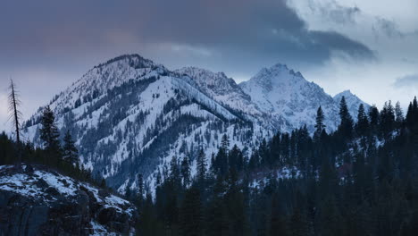 Time-lapse-of-clouds-swirling-over-mountain-peaks-at-sunset