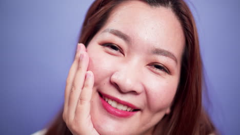 매력적인 아시아 여성의 초상화를 닫고 소프트 포커스 바이올렛 배경-1로 행복한 미소와 자신감 있는 명랑함