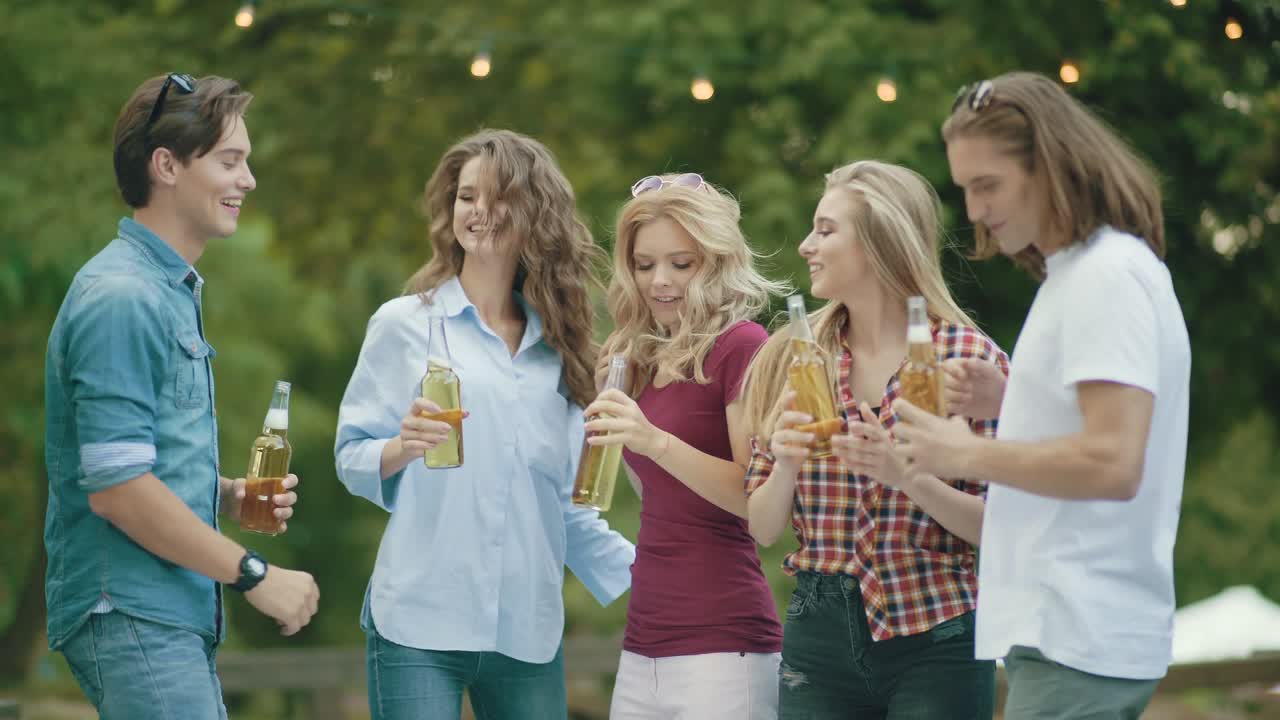 fiesta. amigos felices bailando y bebiendo al aire libre.