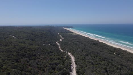 Largo-Camino-De-Tierra-En-Medio-Del-Frondoso-Bosque-De-La-Isla-De-North-Stradbroke-En-Queensland,-Australia