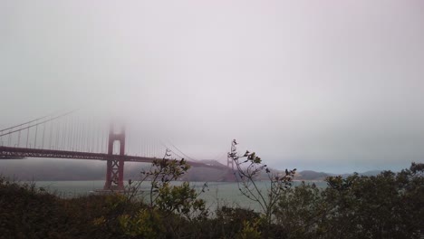 Tiro-De-Cardán-Panorámico-Al-Puente-Golden-Gate-Envuelto-En-Niebla-Desde-El-Presidio-De-San-Francisco,-California