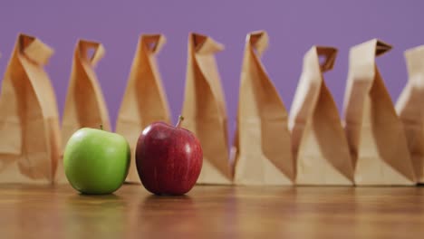 animación de bolsas de almuerzo de papel y frutas en una mesa de madera