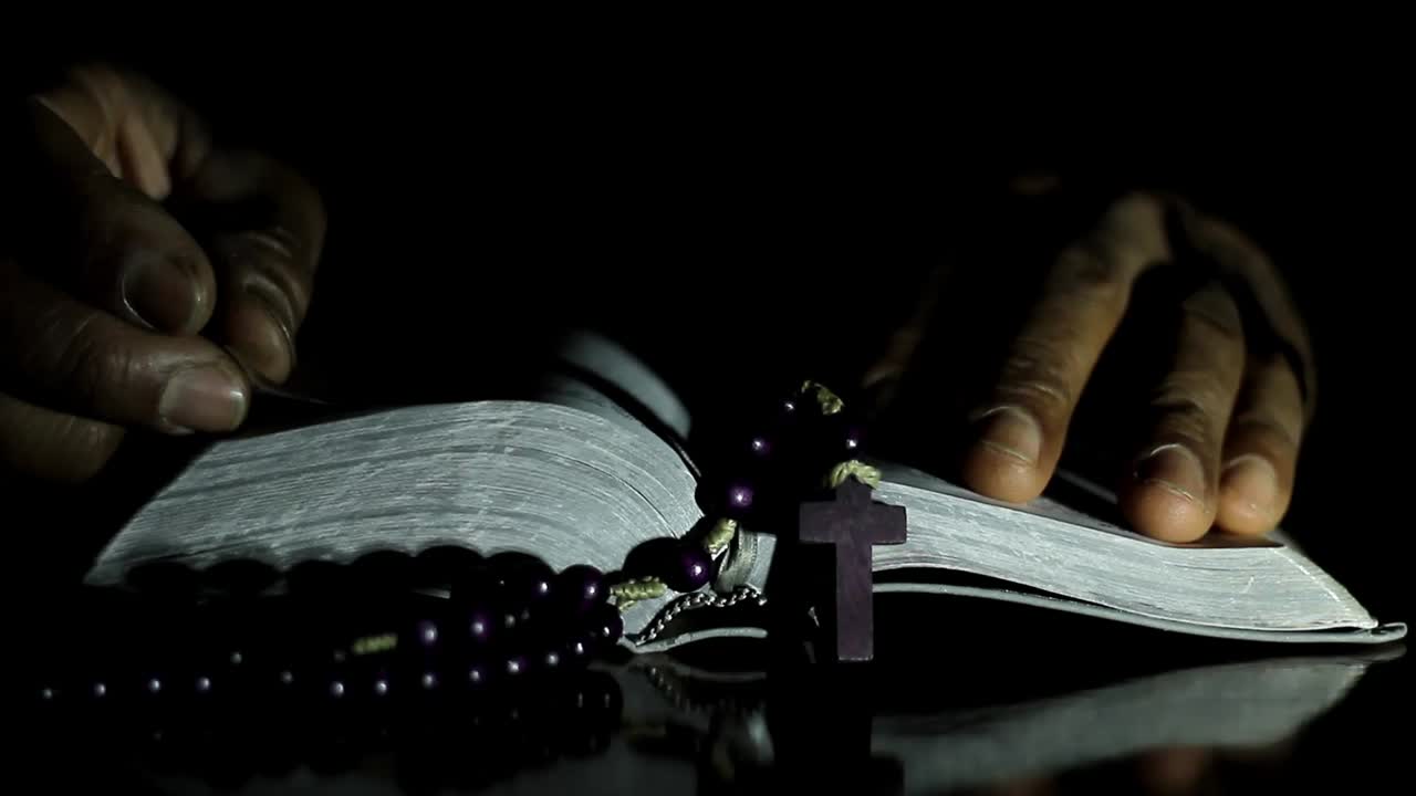 사람 스톡 비디오와 함께 검은 배경에 손을 함께 신에게 기도하는 남자