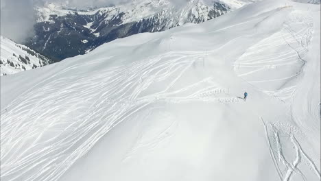 Lonely-person-skiing-in-remote-snowy-mountains,-aerial-view