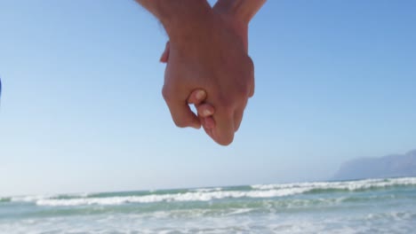 romantic couple walking with hand in hand at beach 4k