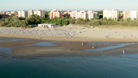 aerial shot of sandy beach with umbrellas and gazebos