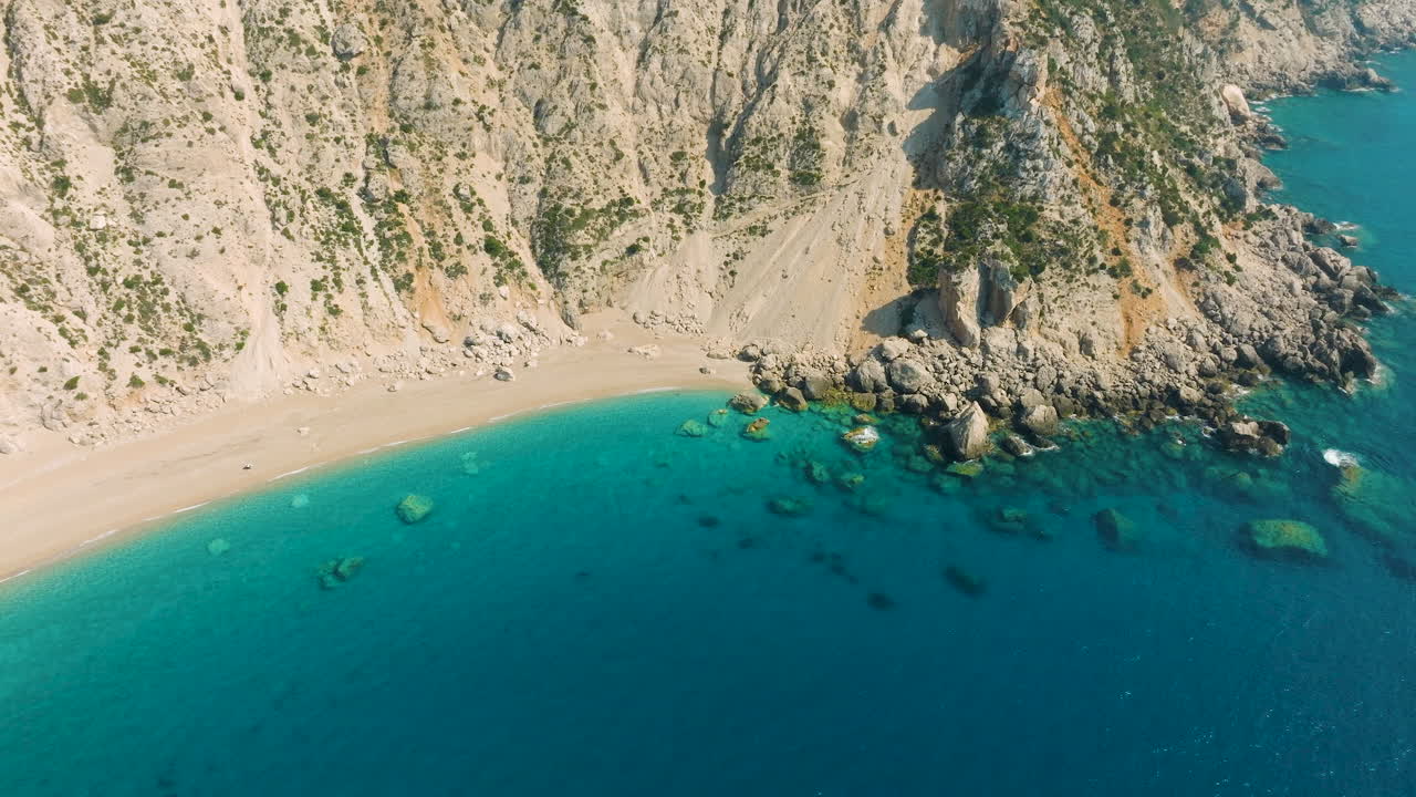 Aerial view of a beautiful beach with turquoise water and rocky cliffs