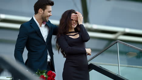 closeup girl waiting for boyfriend. man surprising girlfriend with red roses