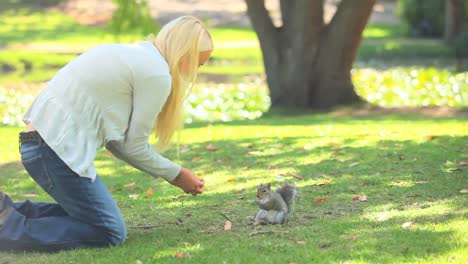 young woman feeding a squirrel