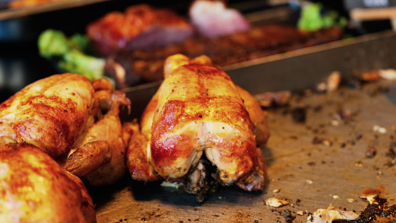 Close up of multiple grilled chickens at a food stand